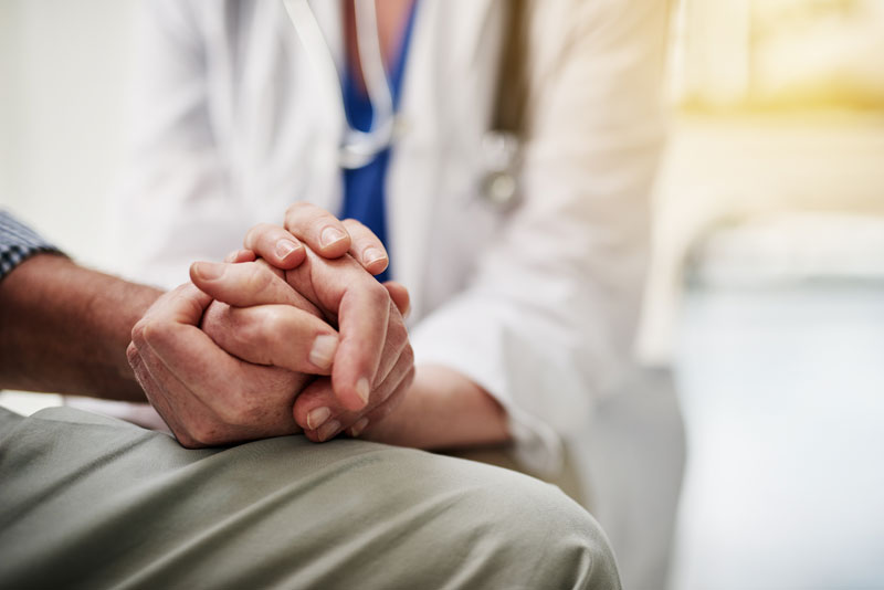 Shot of a doctor holding a senior patient’s hand while sitting in her office Osteoarthritis